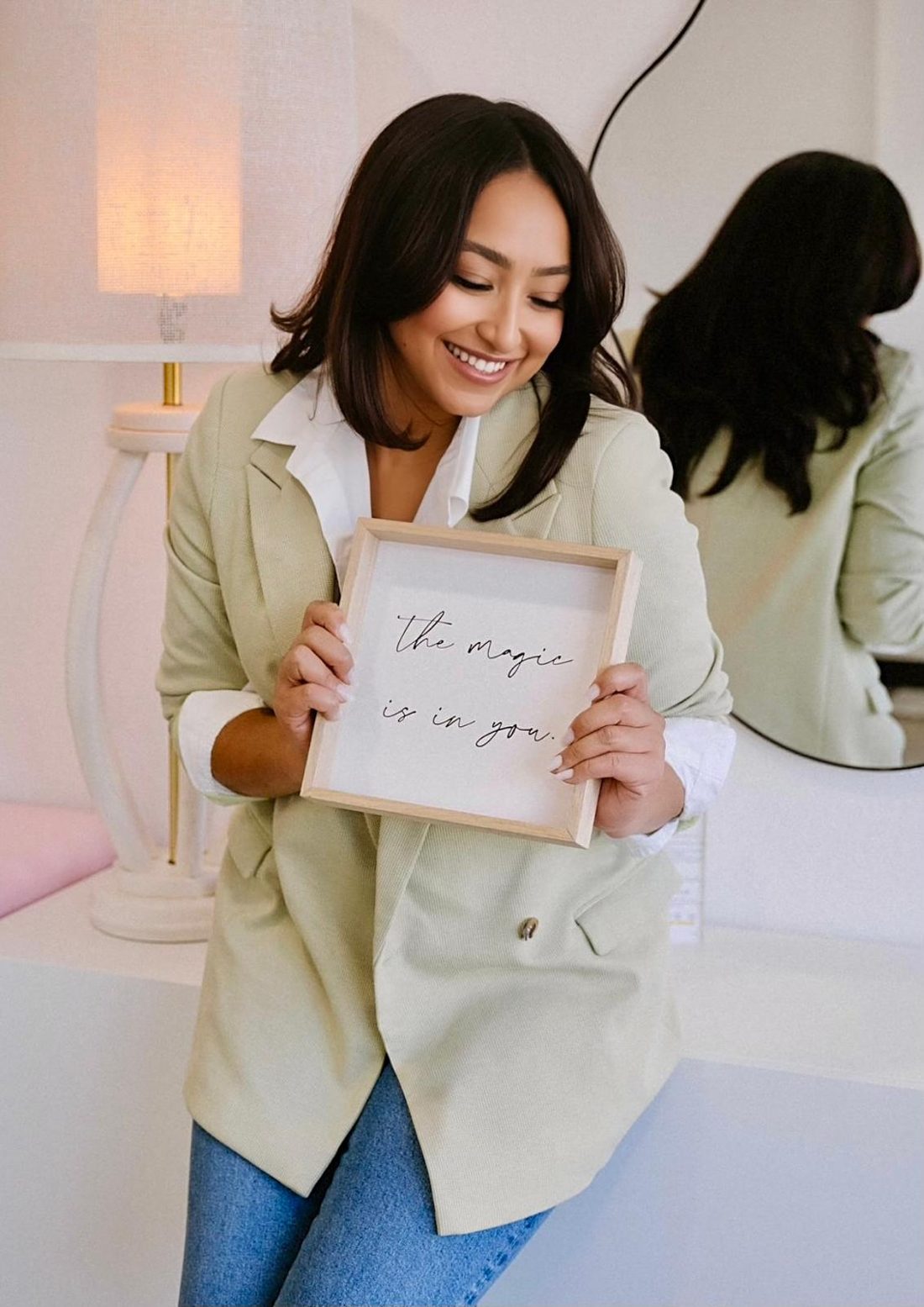 Paige holding a sign that reads the magic is in you